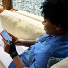 Donna guarda il telefono mentre indossa lo Stabilizzatore per pollice Futuro