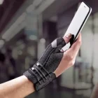 Mano che indossa lo Stabilizzatore per pollice Futuro mentre impugna uno smartphone